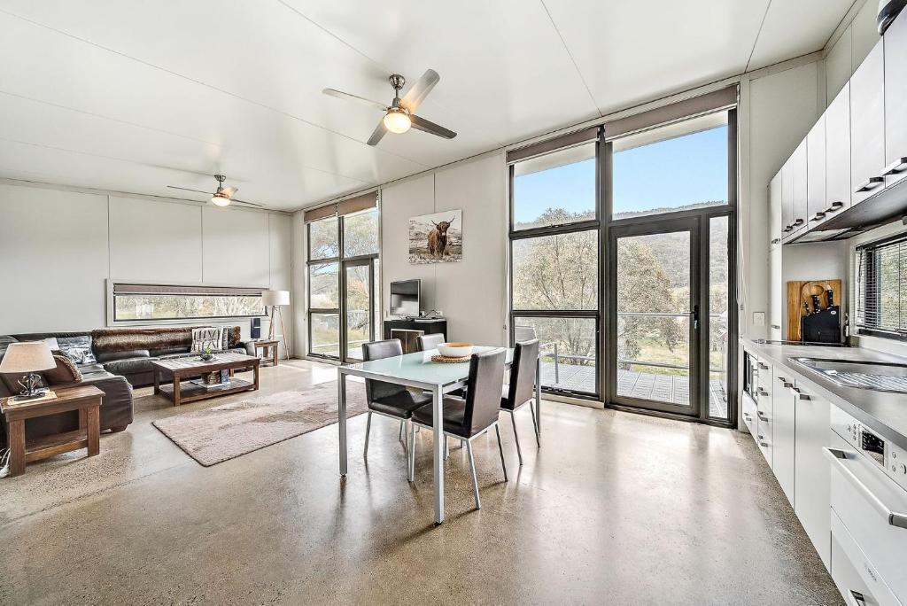 a kitchen and living room with a table and chairs at Ecocrackenback 4 Sustainable chalet close to the slopes in Crackenback