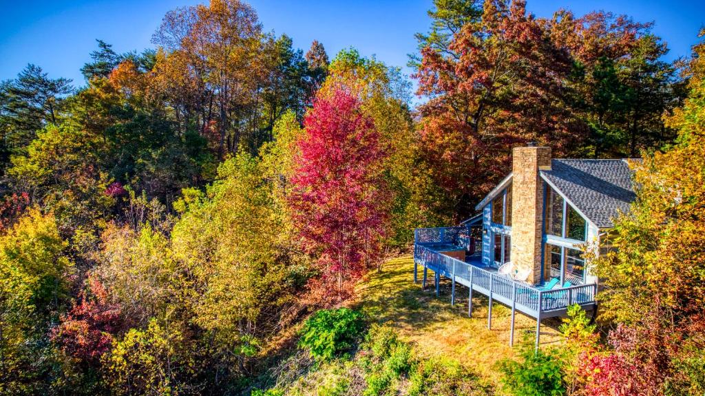 ein Haus inmitten der Bäume in der Unterkunft Barenberg Cabin - Secluded Unobstructed Panoramic Smoky Mountains View with Two Master Suites, Loft Game Room, and Hot Tub in Gatlinburg