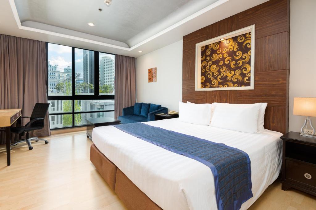 Habitación de hotel con cama grande y escritorio. en Admiral Premier Bangkok, en Bangkok