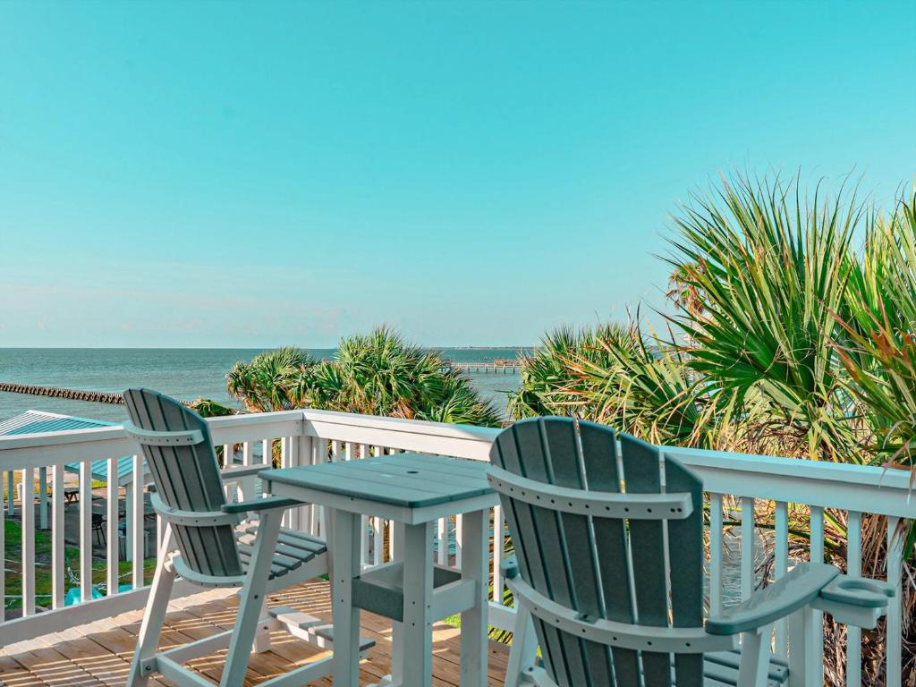 two chairs and a table on a deck overlooking the ocean at Kontiki Bayfront Condo 405 in Rockport