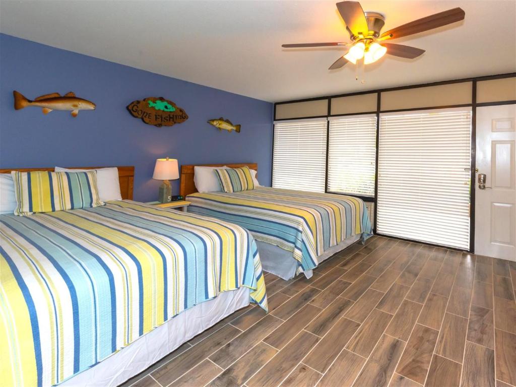 a bedroom with two beds and a ceiling fan at LR 117 - Gone Fishing in Rockport