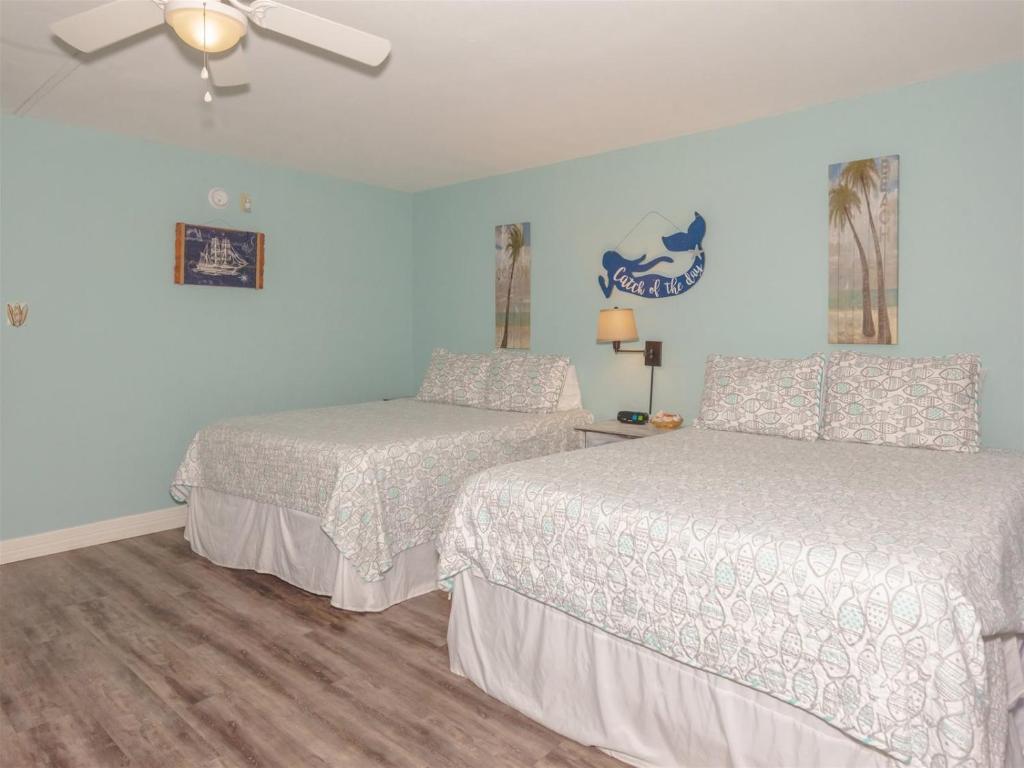 a bedroom with two beds and a ceiling fan at LR 121 - Gone Coastal in Rockport