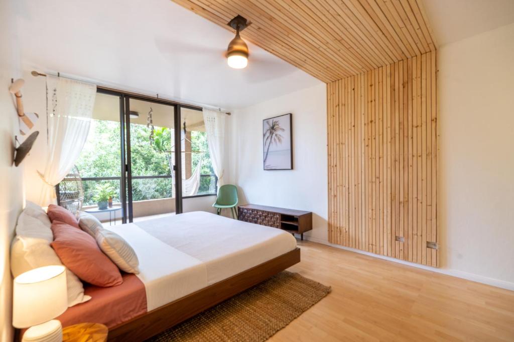 a bedroom with a bed and a large window at Sohana Lifestyle Apartment I Leeven's Home I Kona in Kailua-Kona