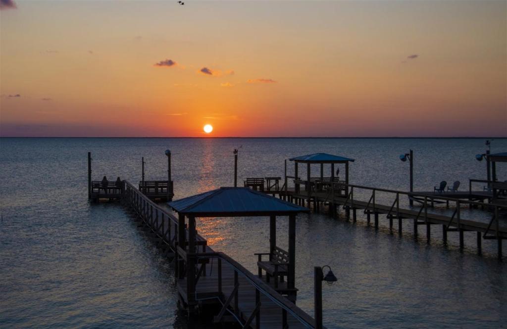 un molo in acqua con il tramonto di Trout Tank a Rockport