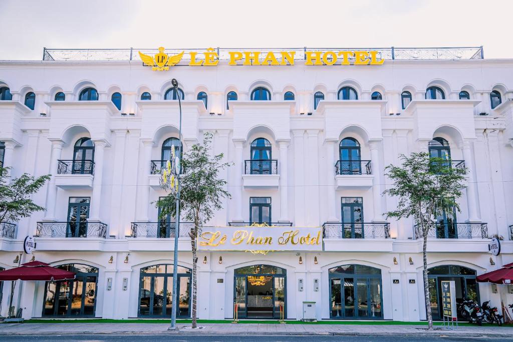 um edifício branco com uma placa que lê o hotel de brincar em Le Phan Hotel em Tây Ninh