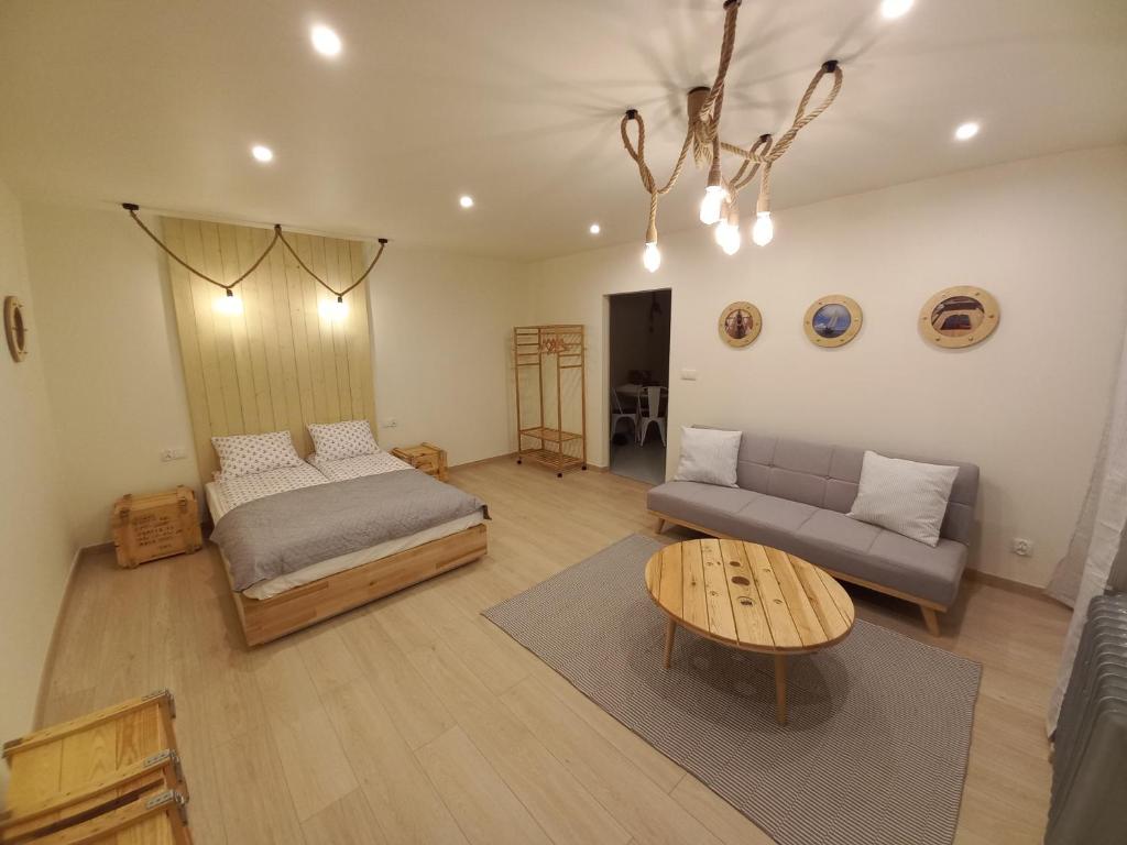 a living room with a bed and a couch at Apartament u Szkutnika in Puck