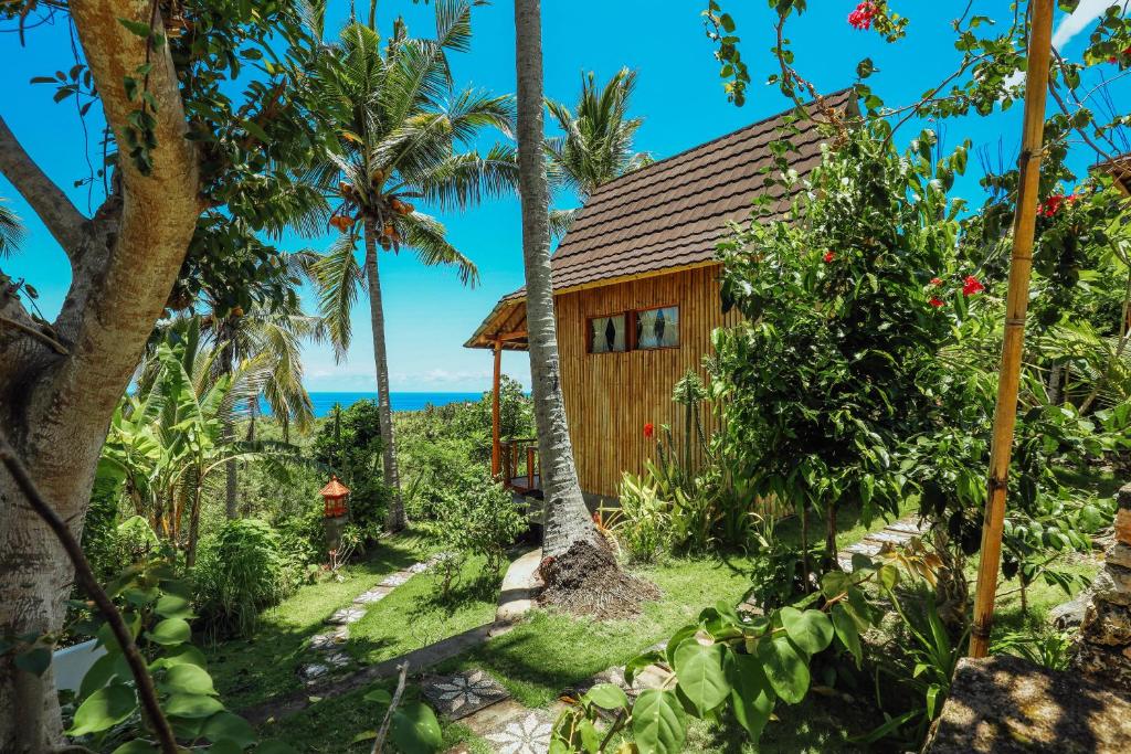 una cabina nella giungla con palme di Atuh Forest Cottage a Nusa Penida