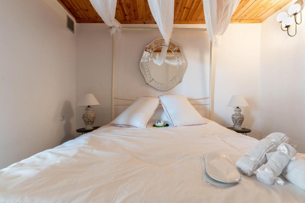 a white bed with white sheets and towels on it at RENAISSANCE in Arachova