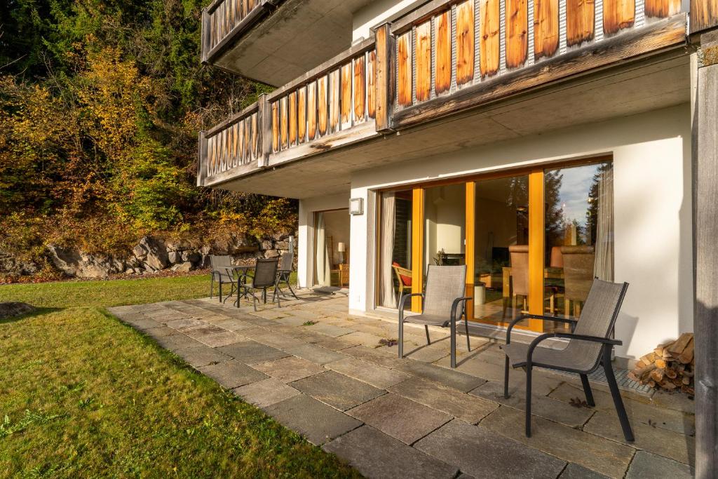 a patio with chairs and a table in a yard at Edelweiss Slope Side in Flims