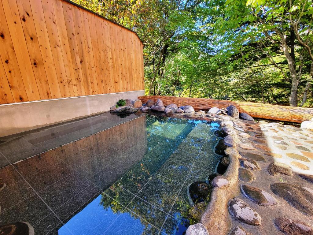 a pool of water with a wooden fence at K's House Nikko - Kinugawa Onsen Hostel in Nikko