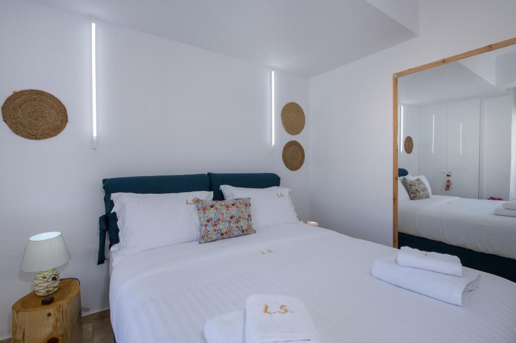 レティムノ・タウンにあるLucky Suitesのベッドルーム(鏡付きの大きな白いベッド1台付)