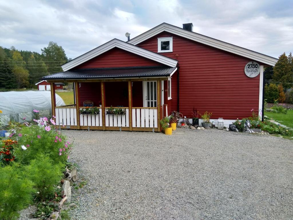una casa roja con una entrada de grava delante de ella en Irina & Paul House at Krokedal en Fetsund