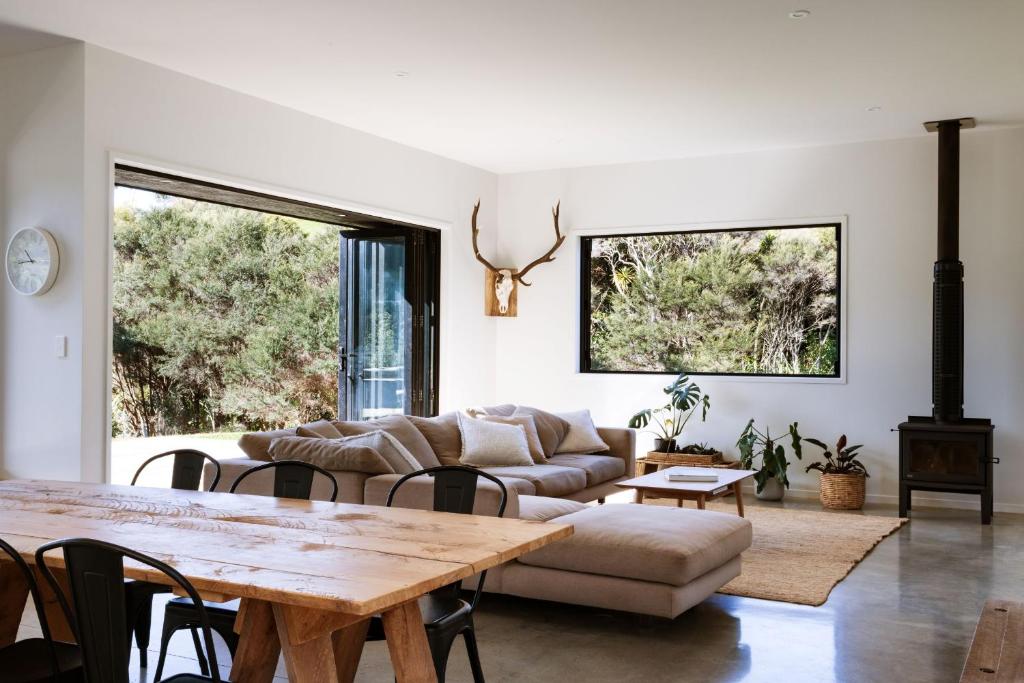 a living room with a couch and a table at Modern Raglan Hideaway in Raglan