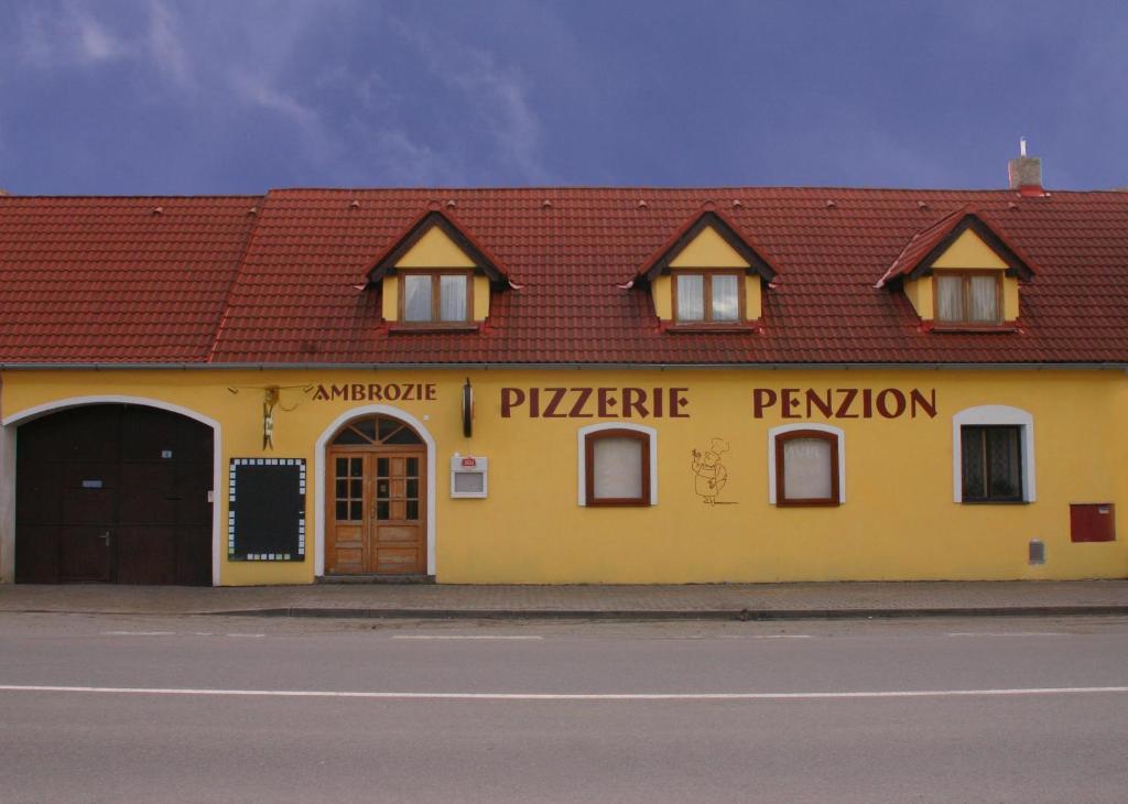 un edificio amarillo al lado de una calle en Penzion Ambrozie, en Seč
