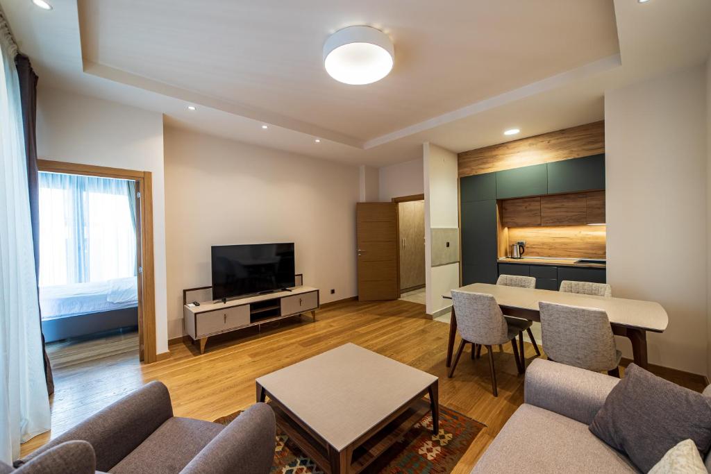 a living room with a couch and a table and a tv at Elite apartments Podgorica in Podgorica