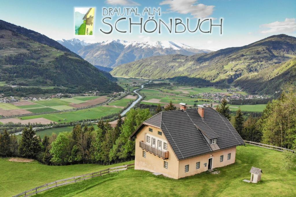 dom na wzgórzu z górami w tle w obiekcie Drautal Alm Schönbuch w mieście Steinfeld
