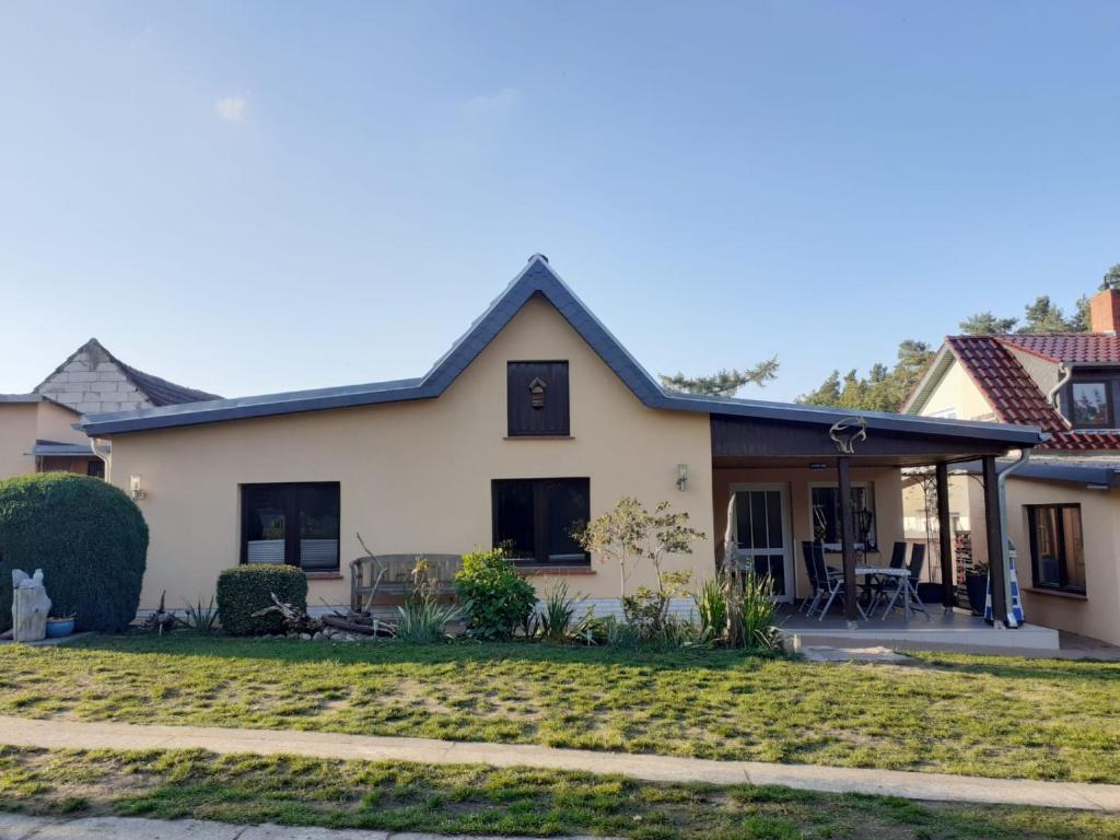 ein weißes Haus mit einer Veranda und einem Hof in der Unterkunft Ferienhaus Fiete in Plau am See