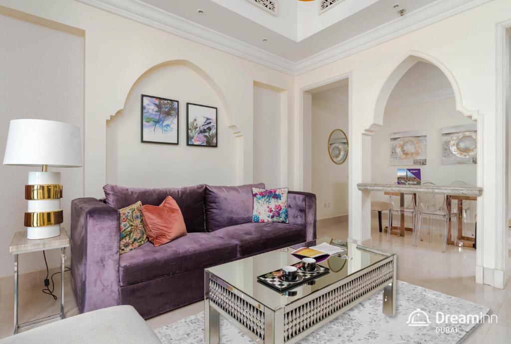 a living room with a purple couch and a table at Dream Inn Apartment- Tajer Souk Al Bahar in Dubai