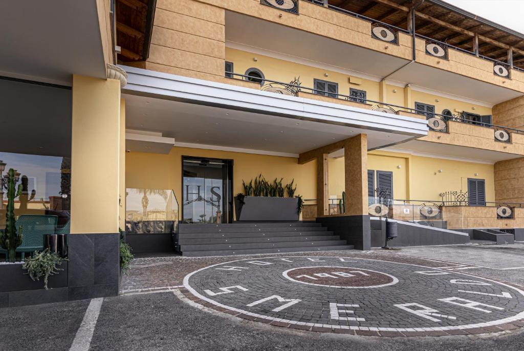 um edifício com uma placa no chão à sua frente em Hotel Smeraldo em Qualiano