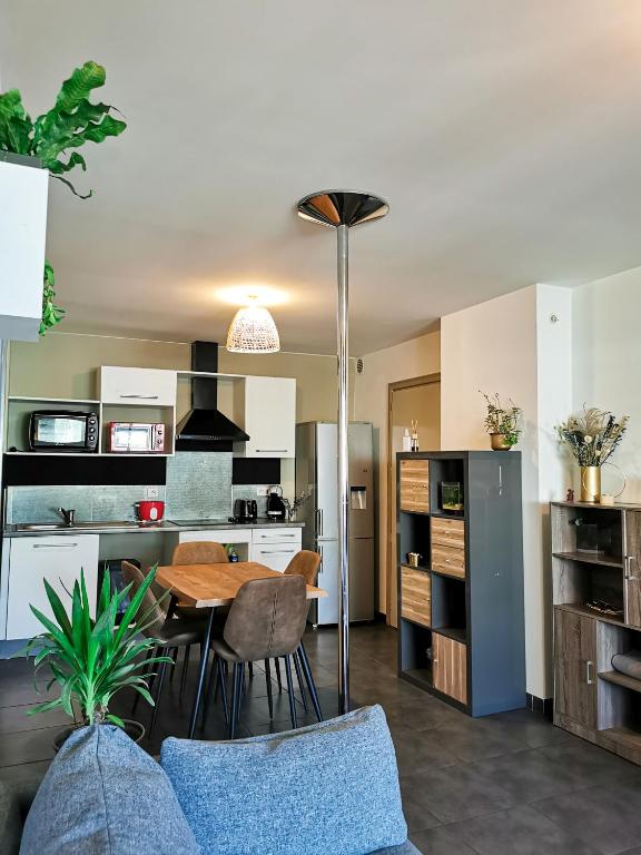 eine Küche und ein Wohnzimmer mit einem Tisch und Stühlen in der Unterkunft La Perle d'Akoya in Saint-Leu