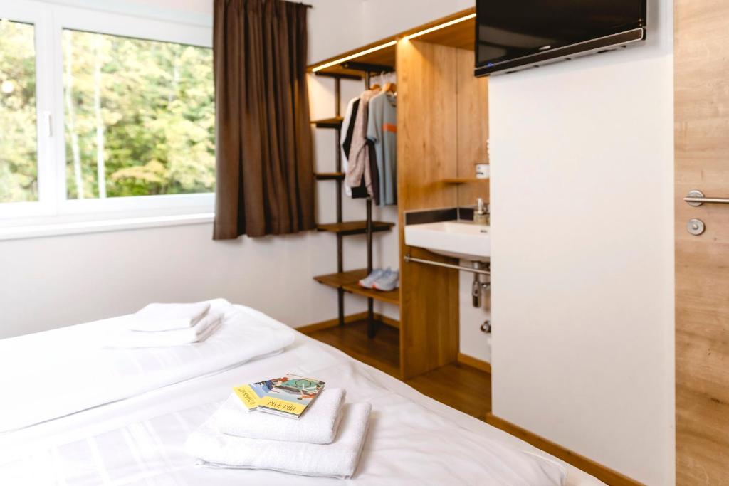 a room with a bed and a sink and a window at zum Sigismund - kiss & sleep in St. Wolfgang