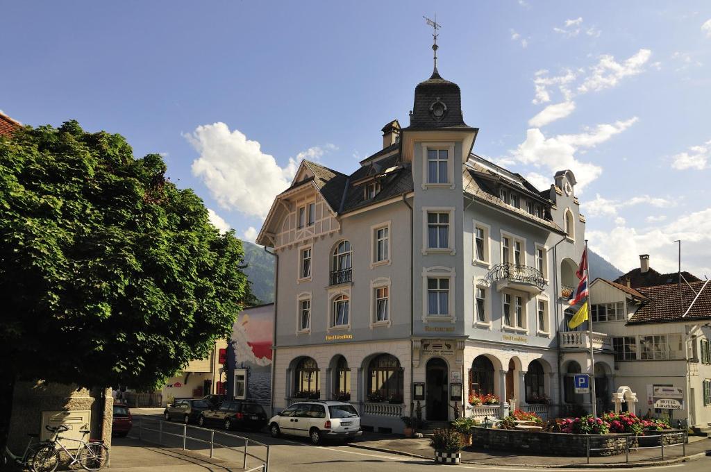 ein großes weißes Gebäude mit einem Uhrturm oben in der Unterkunft Hotel Lötschberg in Interlaken
