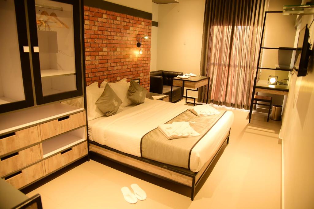 a hotel room with a bed and a brick wall at Vits Select Kudro Destinn in Mangalore