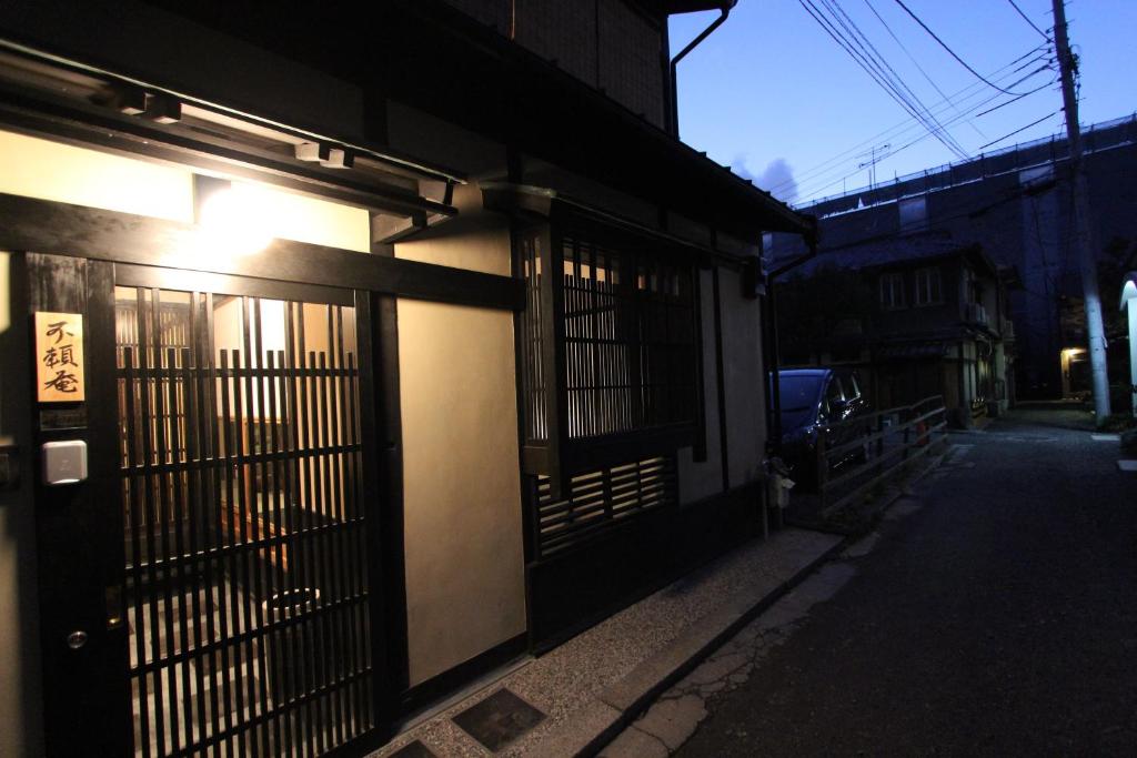 a building with a gate on the side of a street at Brian Machiya Inn in Kyoto