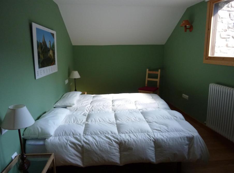 a bedroom with a white bed in a green wall at CHECK-IN CASAS Borda Blaner in Villanova