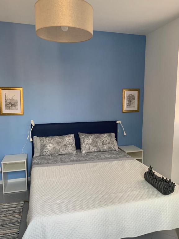 1 dormitorio azul con 1 cama con pared azul en Columbus Apartment, en Chiavari