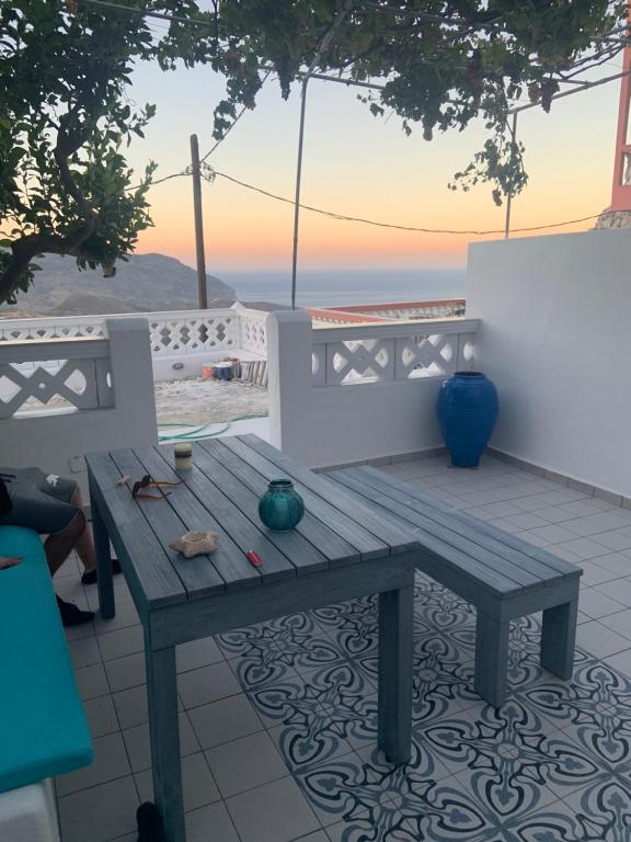 a picnic table on a patio with a view of the ocean at Thea Menetes in Karpathos Town