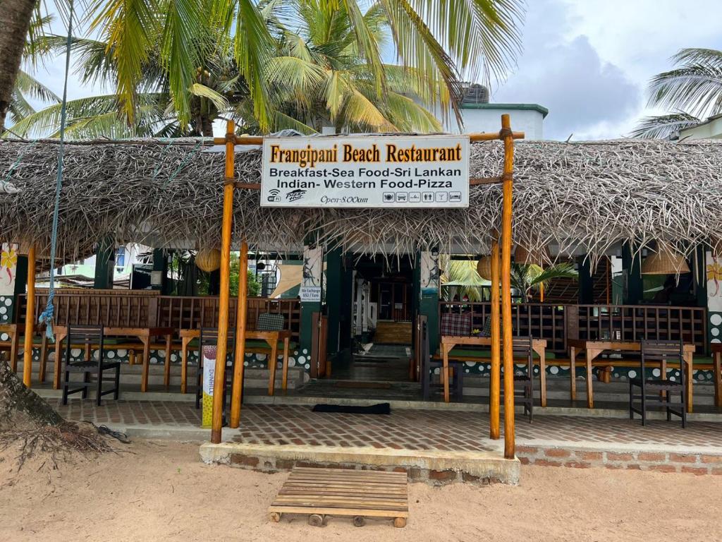 ein Schild vor einem Restaurant am Strand in der Unterkunft Frangipani Beach Villa in Tangalle