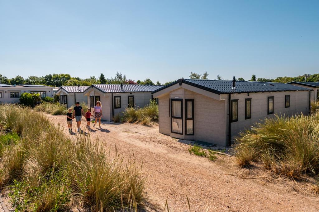 Un groupe de personnes debout devant une rangée de maisons dans l'établissement EuroParcs Poort van Zeeland, à Hellevoetsluis