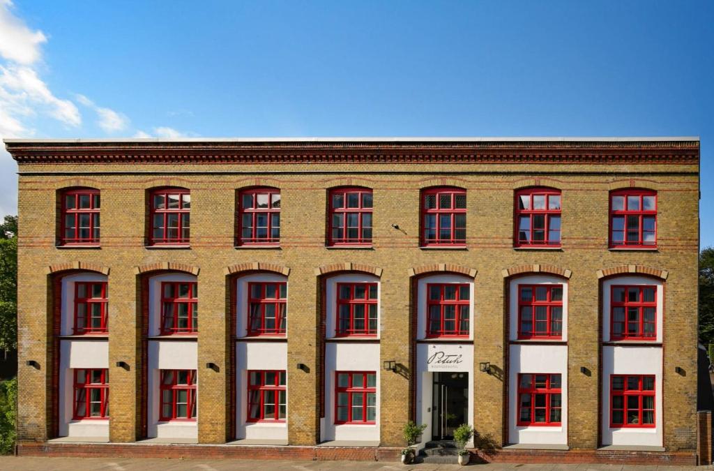 um grande edifício de tijolos com janelas vermelhas e brancas em Boutiquehotel Petuh em Flensburg