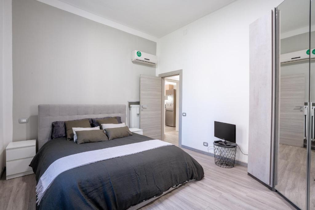 ein Schlafzimmer mit einem großen Bett und einem TV in der Unterkunft Maneki Murri 124 bologna in Bologna