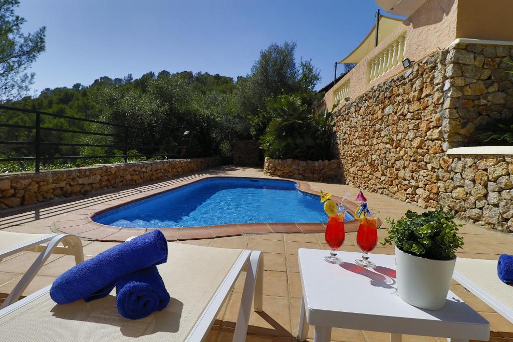 una piscina en un patio con 2 sillas y una mesa en Villa Magdalena, en Calviá