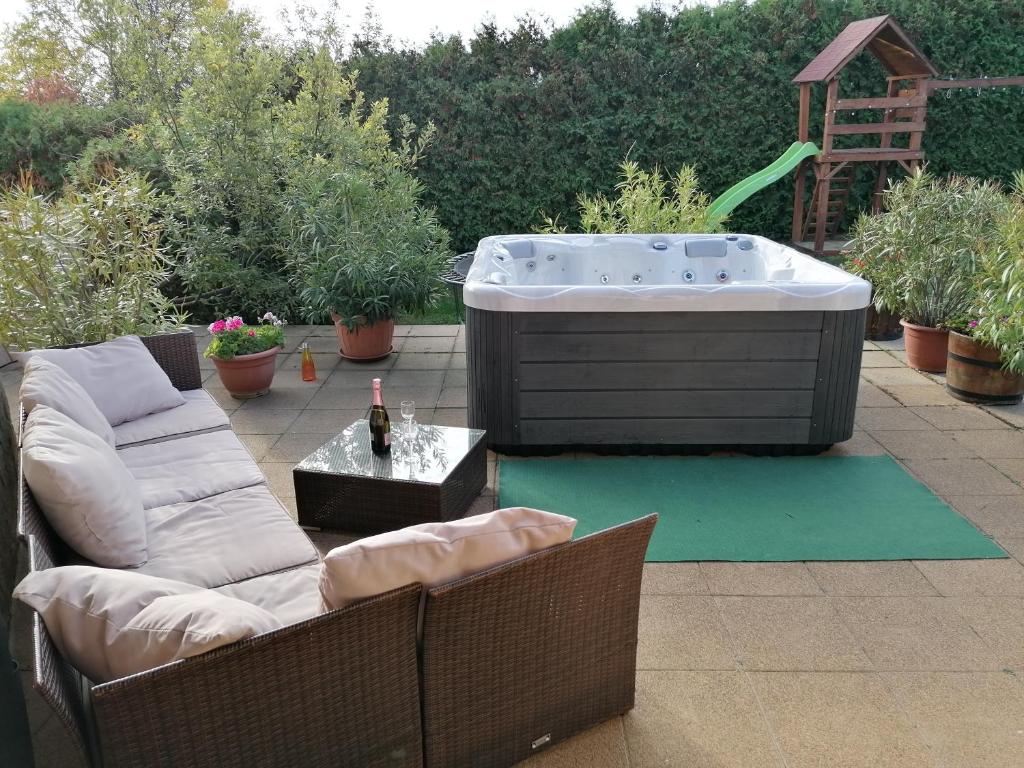 a patio with a hot tub and a couch and a table at Vár-Lak Resort in Balatonederics