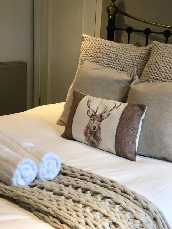 a bed with a pillow with a picture of a deer on it at The White Hart Inn in Ingatestone