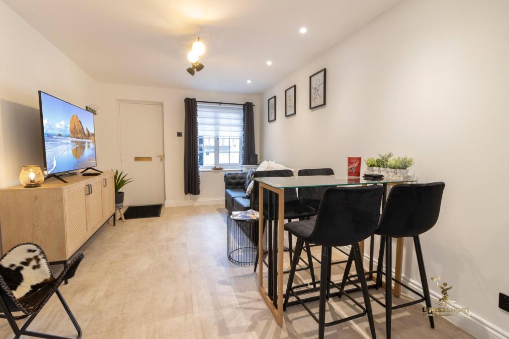 a living room with a table and some chairs at Spacious City Centre Apt Near Cathedral in Exeter