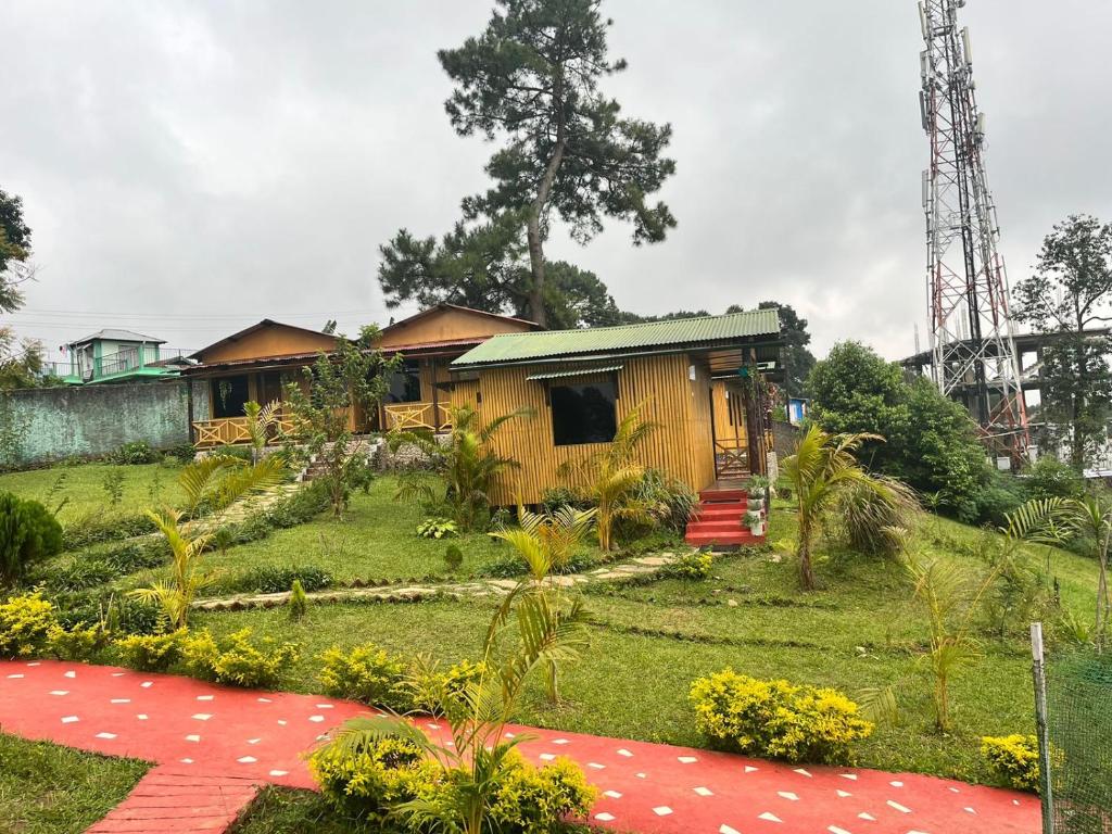 a house in the middle of a yard with a red carpet at Odyssey Stays Umbir, Umiam Lake in Mawlyngkhung