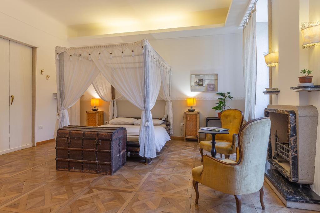 得利雅斯特的住宿－Città del Capo，一间卧室配有一张天蓬床和一把椅子