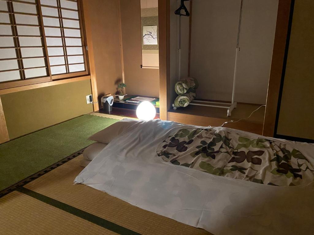 a bedroom with a bed in a room with a window at Takayama Ninja House in Takayama