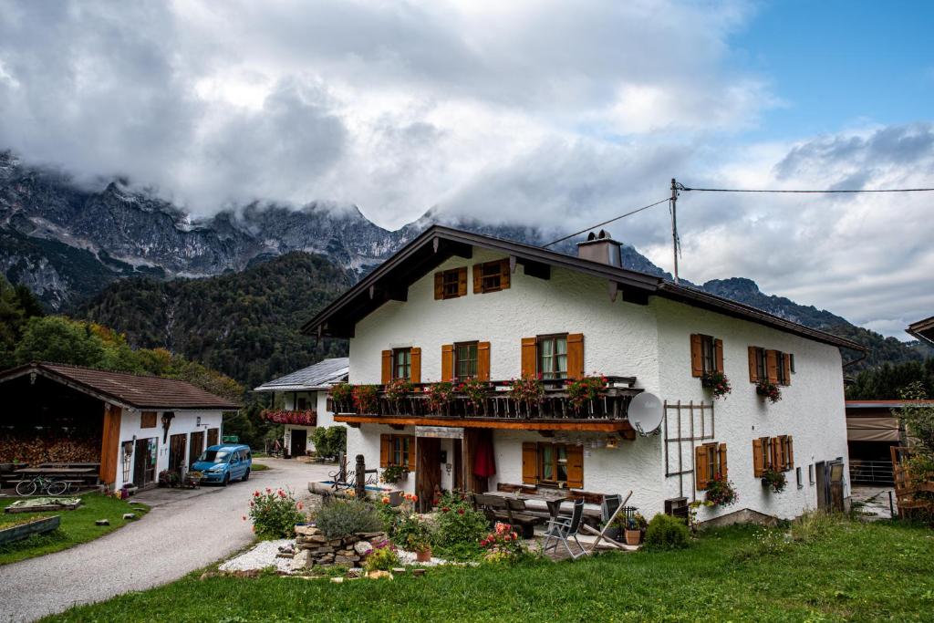 a large white house with a balcony on a mountain at Ferienwohnung Lippenlehen in Marktschellenberg