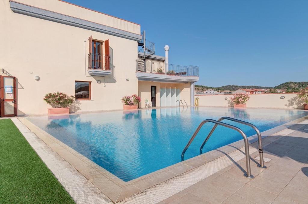 uma imagem de uma piscina numa villa em Apartments in residence with swimming pool in Villasimius em Villasimius
