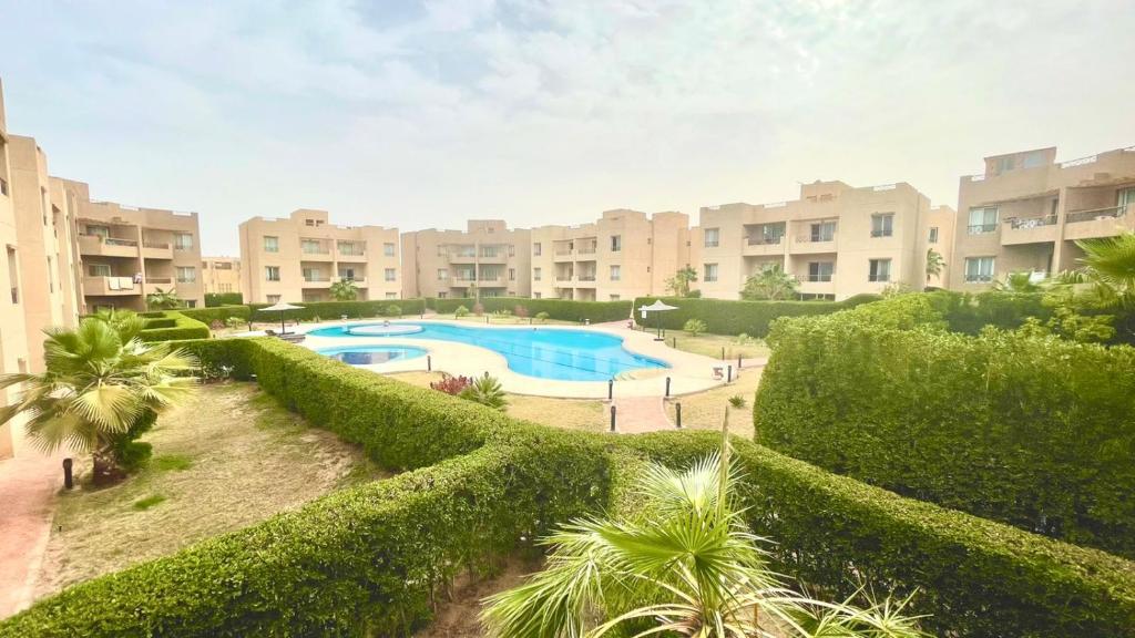 a resort with a swimming pool and trees and buildings at Luxury Two bedrooms flat with pool view in Sharm El Sheikh