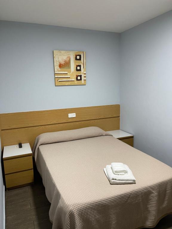 1 dormitorio con 1 cama y una foto en la pared en Hostal Tres Hermanos, en Getafe