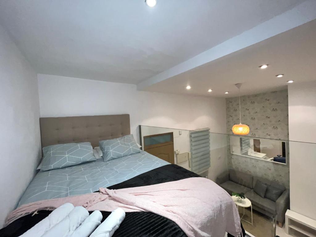 een slaapkamer met een groot bed en een bank bij Encantador Puente Segovia Caramuel in Madrid