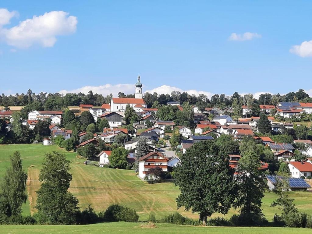 een klein stadje met een klokkentoren op een heuvel bij Haus Amann in Prackenbach
