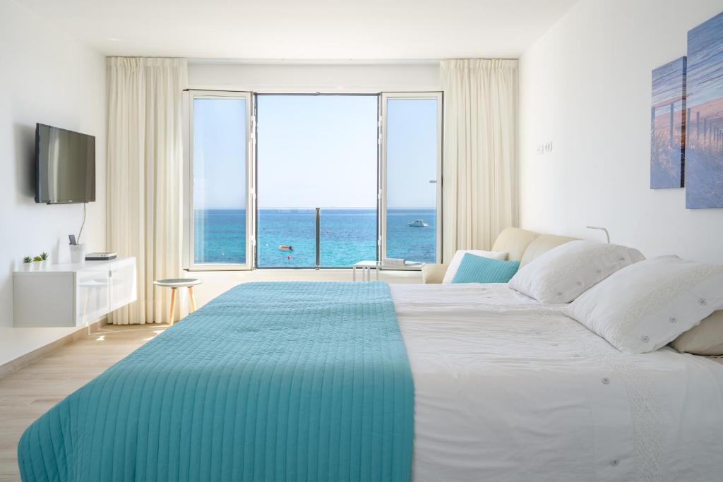 a bedroom with a large bed with a view of the ocean at Casa Roman in Punta de Mujeres