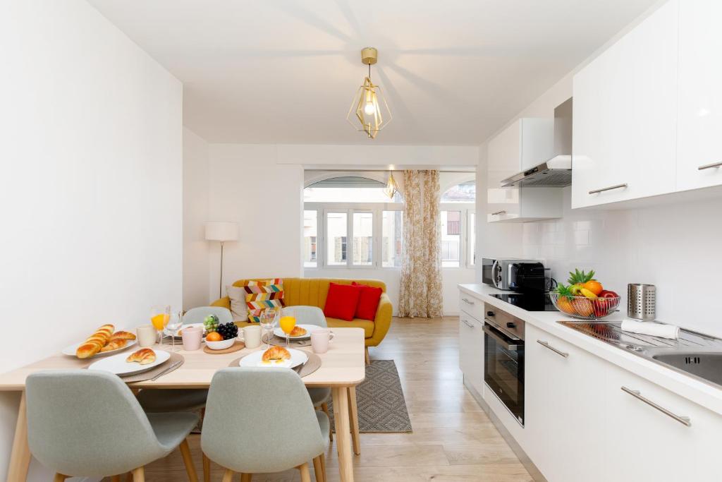 een keuken en een woonkamer met een tafel en stoelen bij Lumière YourHostHelper in Cannes
